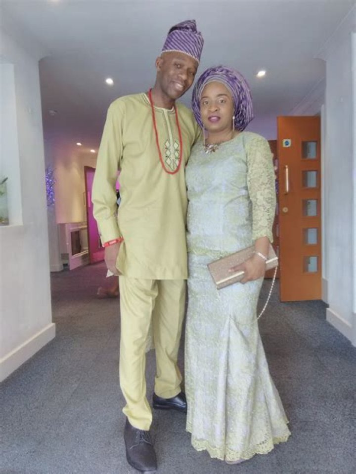 David Olawale Ayinde posing with his wife by wearing clay colored outfit.
